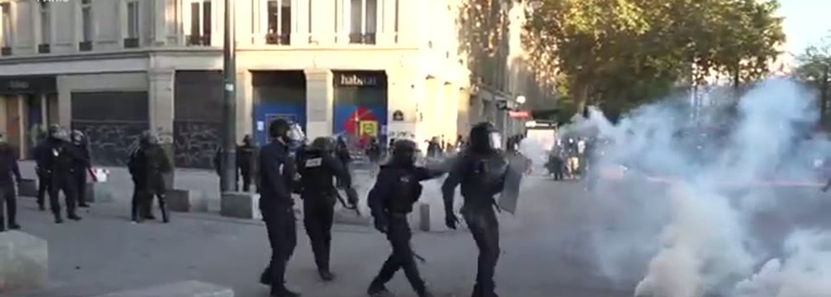 Riot police advance as tear gas spreads on a Paris street