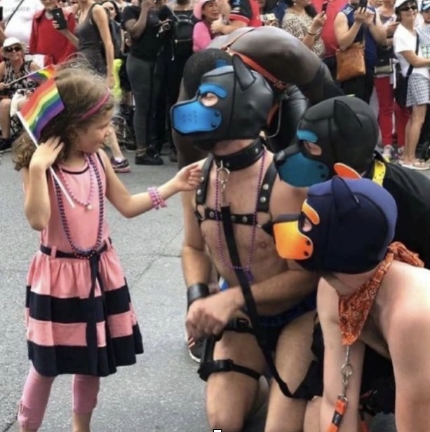 Child holding a rainbow flag at a Pride parade
