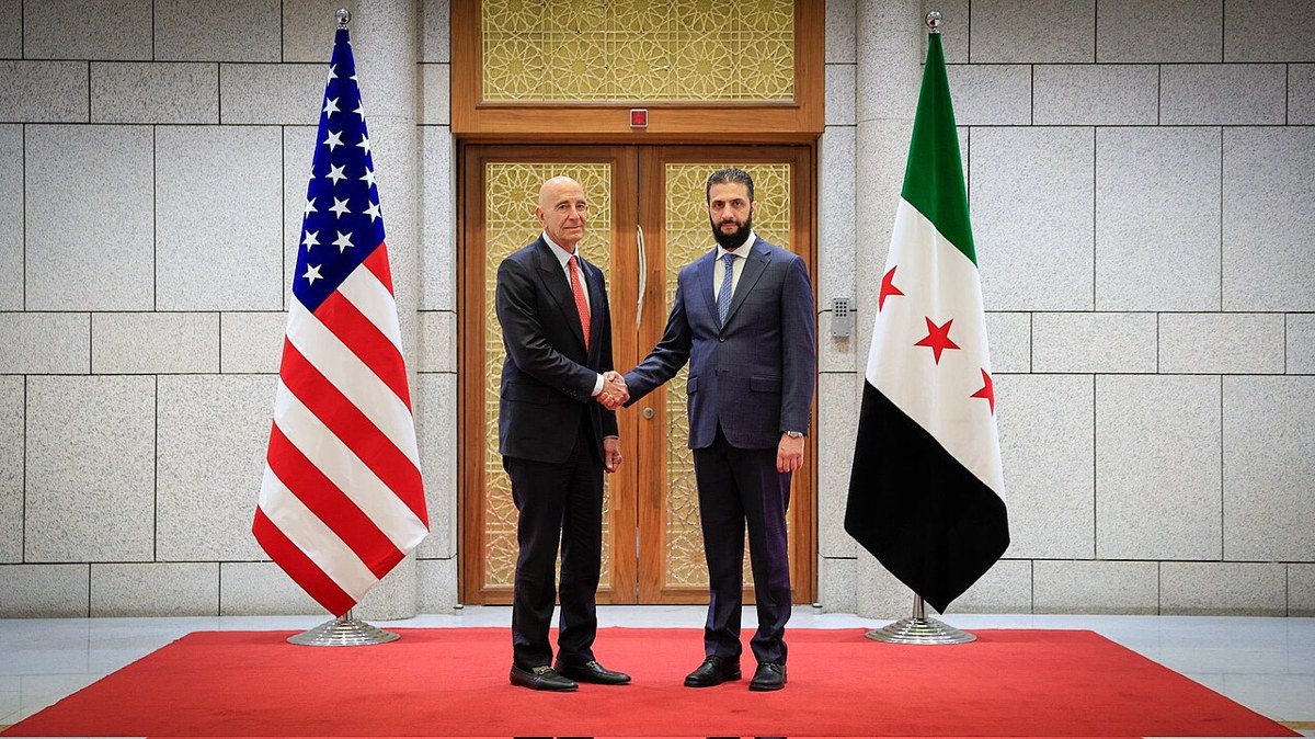 Tom Barrack shakes hands with Syrian President Ahmed al-Sharaa