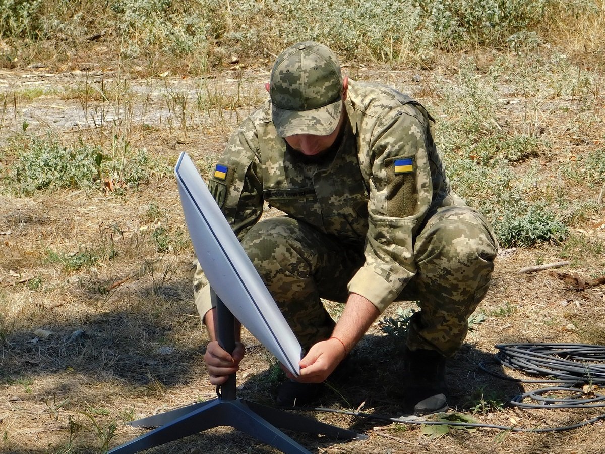 A Ukrainian soldier sets up a Starlink terminal