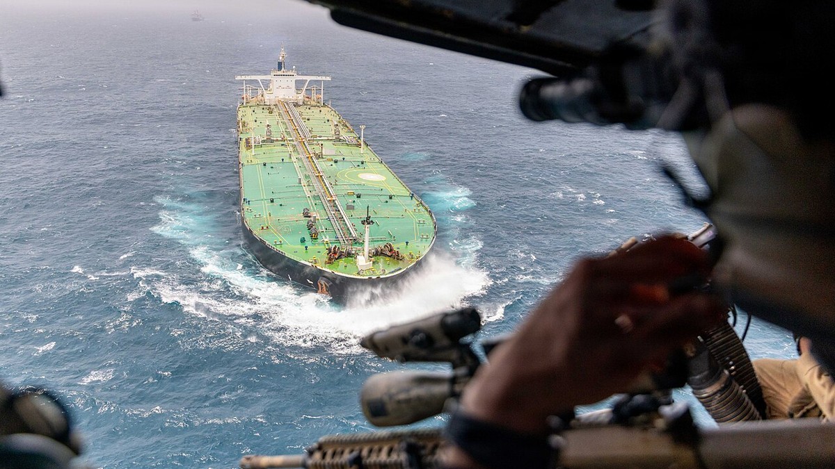 View from a helicopter of a crude oil tanker underway with a U.S. Marine in the foreground